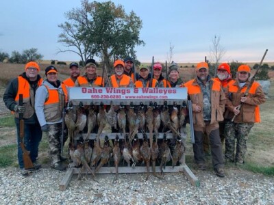 Group of hunters standing with pheasant kill